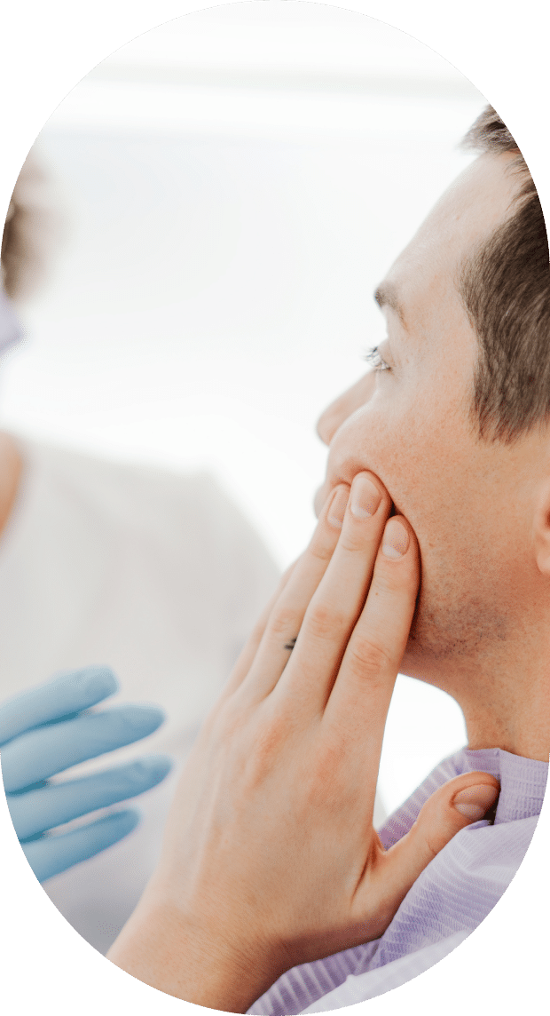 A man receiving a dental cleaning from a dentist in a clinical setting, showcasing oral hygiene practices.