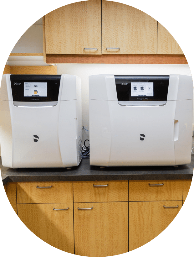 Two white machines positioned on a countertop, showcasing a clean and organized workspace