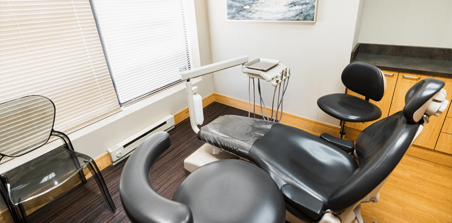 A dental chair positioned in a well-lit room featuring a window, creating a bright and inviting atmosphere