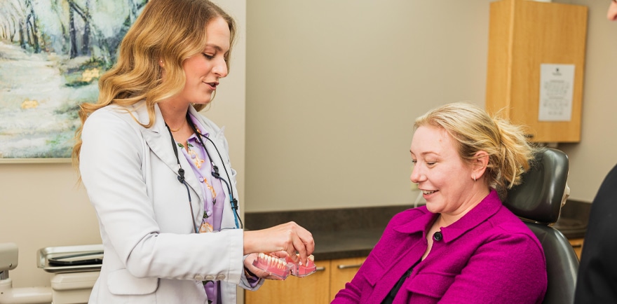 A doctor checks a woman's blood pressure during a routine medical examination in a clinical setting