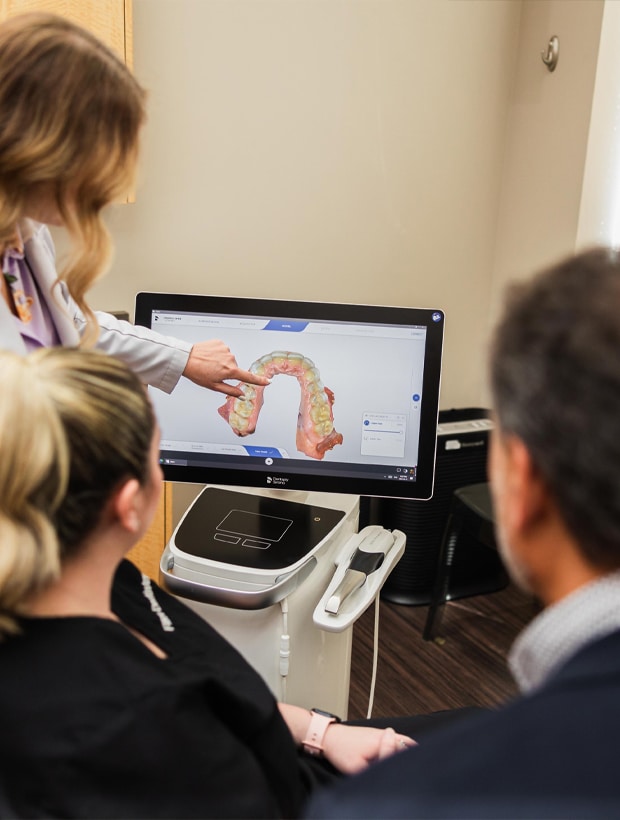 A woman demonstrates computer information to a patient during a consultation in a professional setting