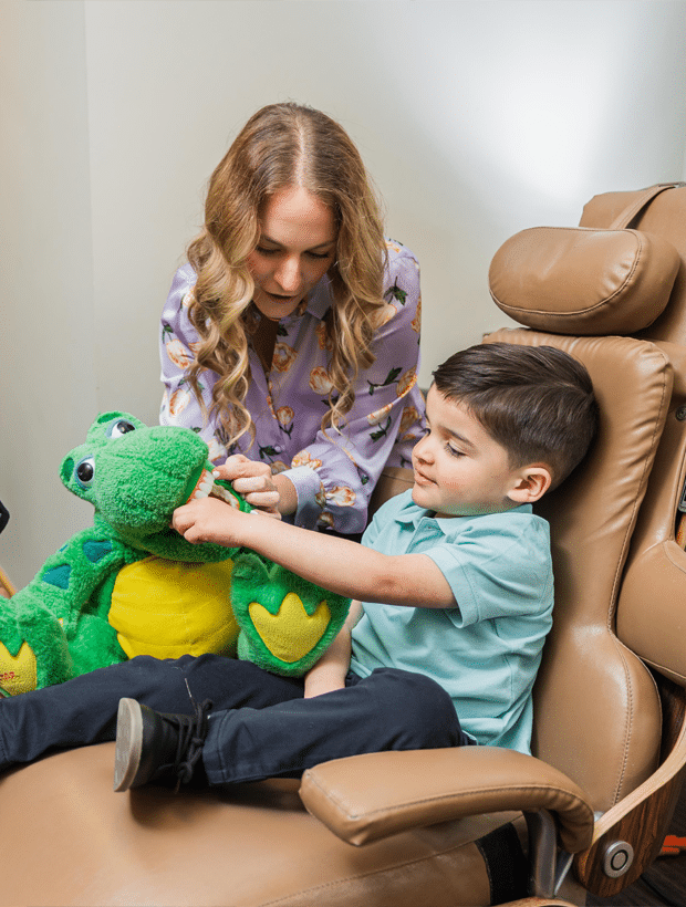 A woman and a boy seated together in a chair, sharing a moment of connection and comfort