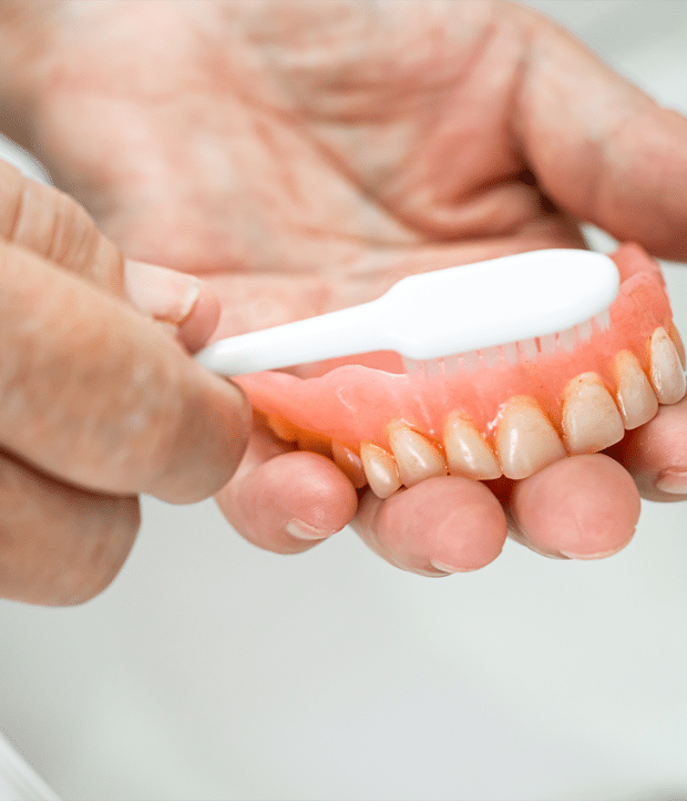 A person brushing their teeth with a toothbrush, promoting good oral hygiene and daily dental care practices