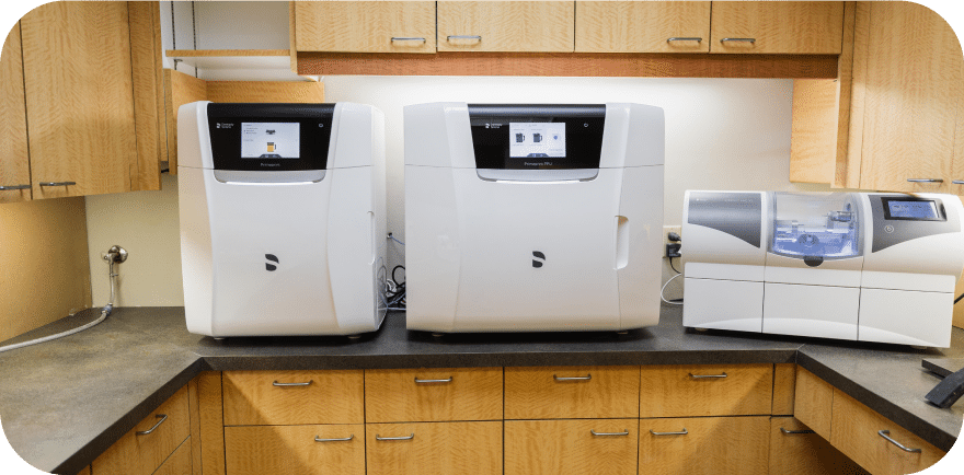 Three white kitchen machines are neatly arranged on a countertop, showcasing a clean and organized culinary space