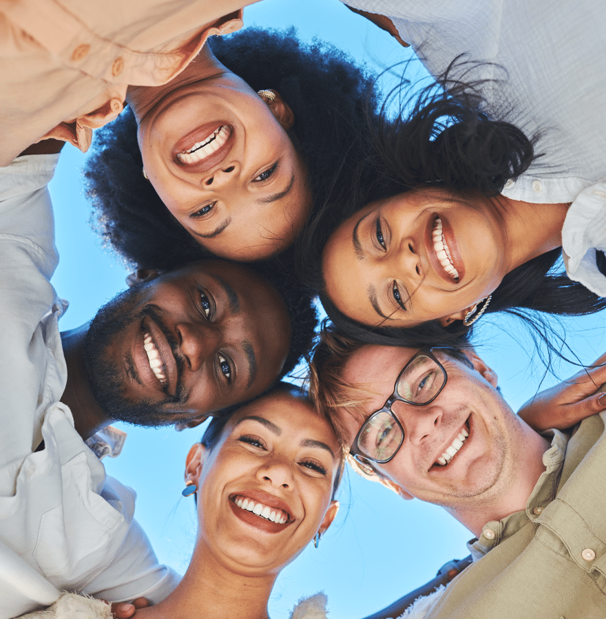 A diverse group of people smiling and looking upwards, conveying joy and positivity in a shared moment