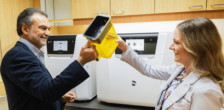 A man and woman in a laboratory holding a yellow cloth, engaged in a collaborative task